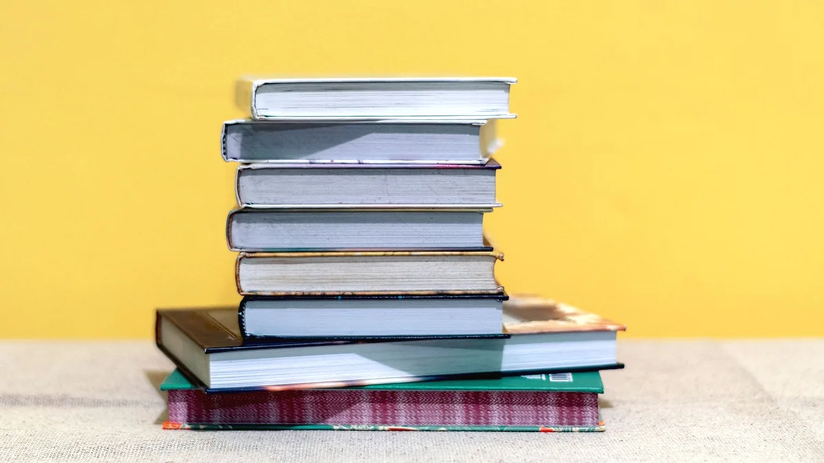 A stack of hardback books on a table.