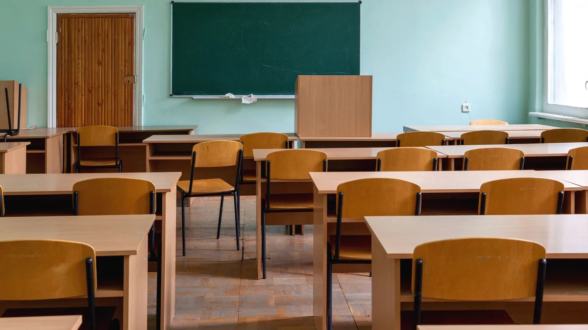An empty classroom with the desks in rows.