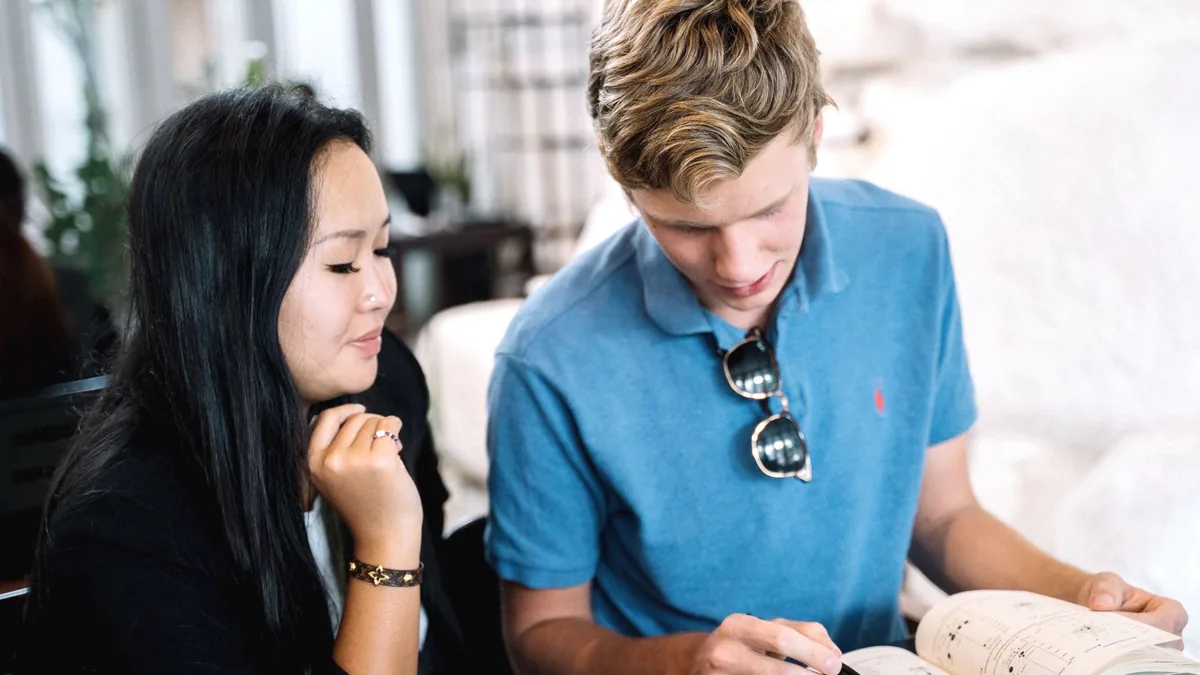 Two people going through written notes together.