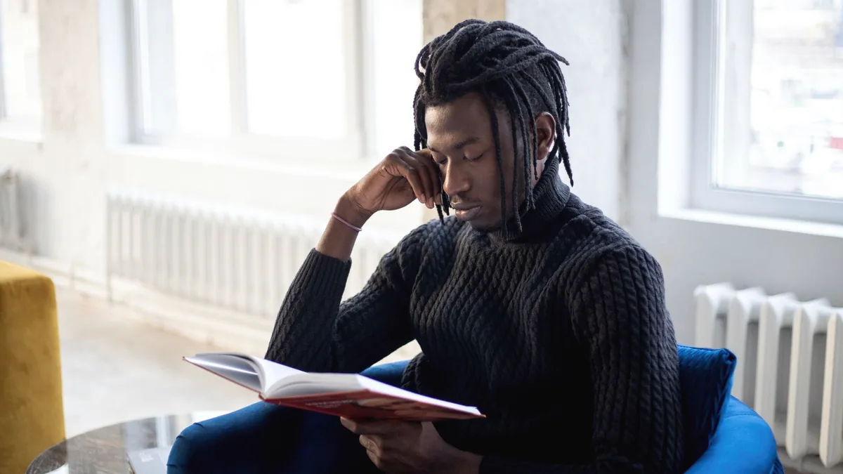 Someone reading a page over to themselves by a window.