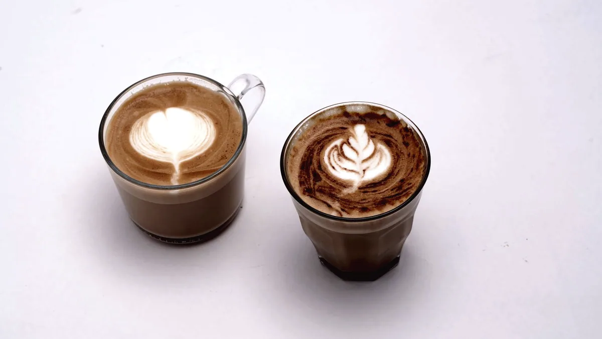 Two cups side by side on a table, alike but not the same.