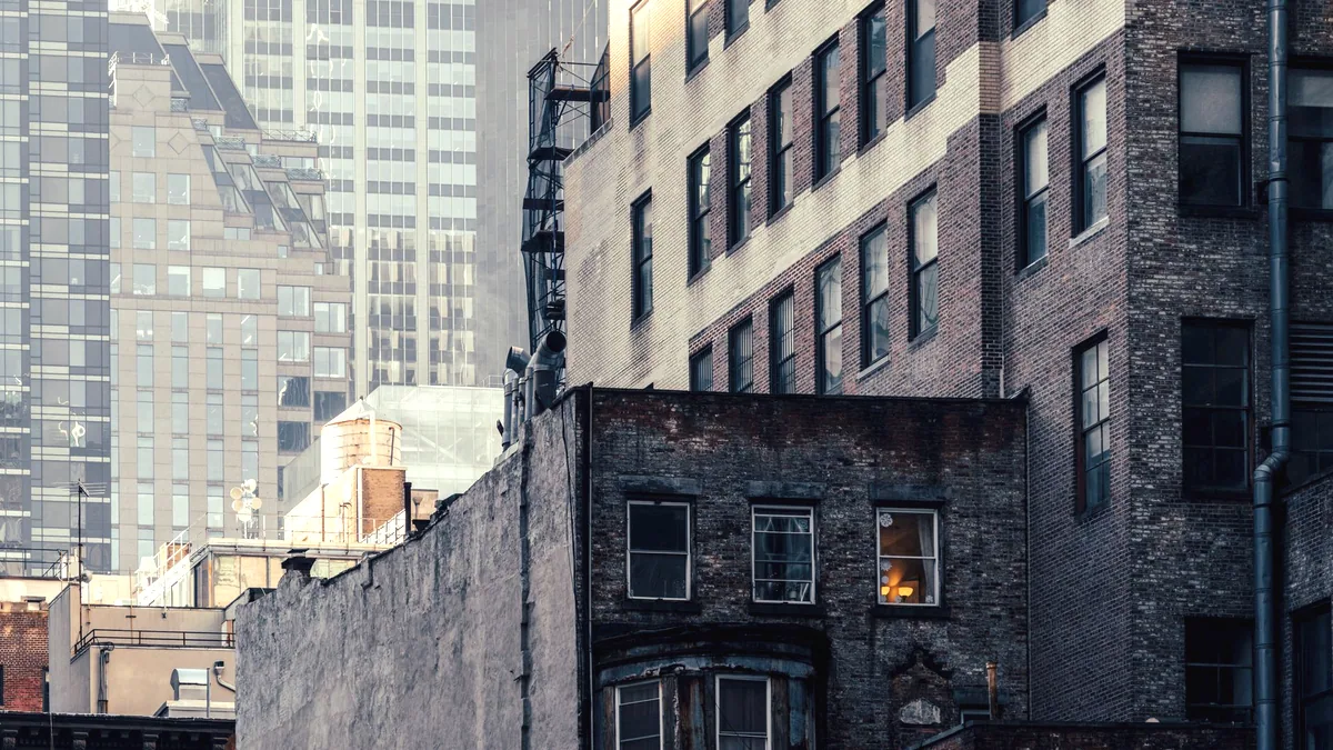 A brick building with a fire escape on a New York street.