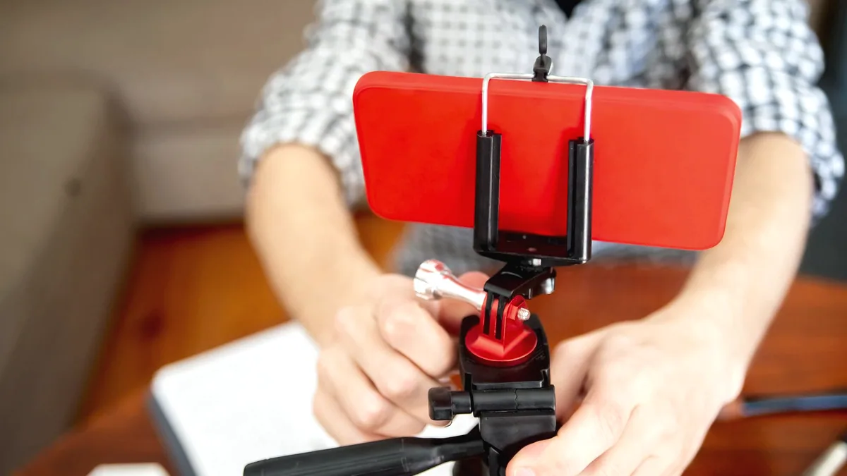 A phone on a small tripod, recording.
